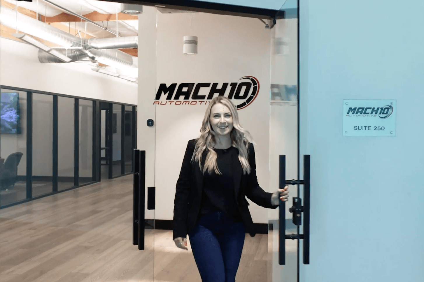 Person entering Mach 10 Automotive beside the office logo